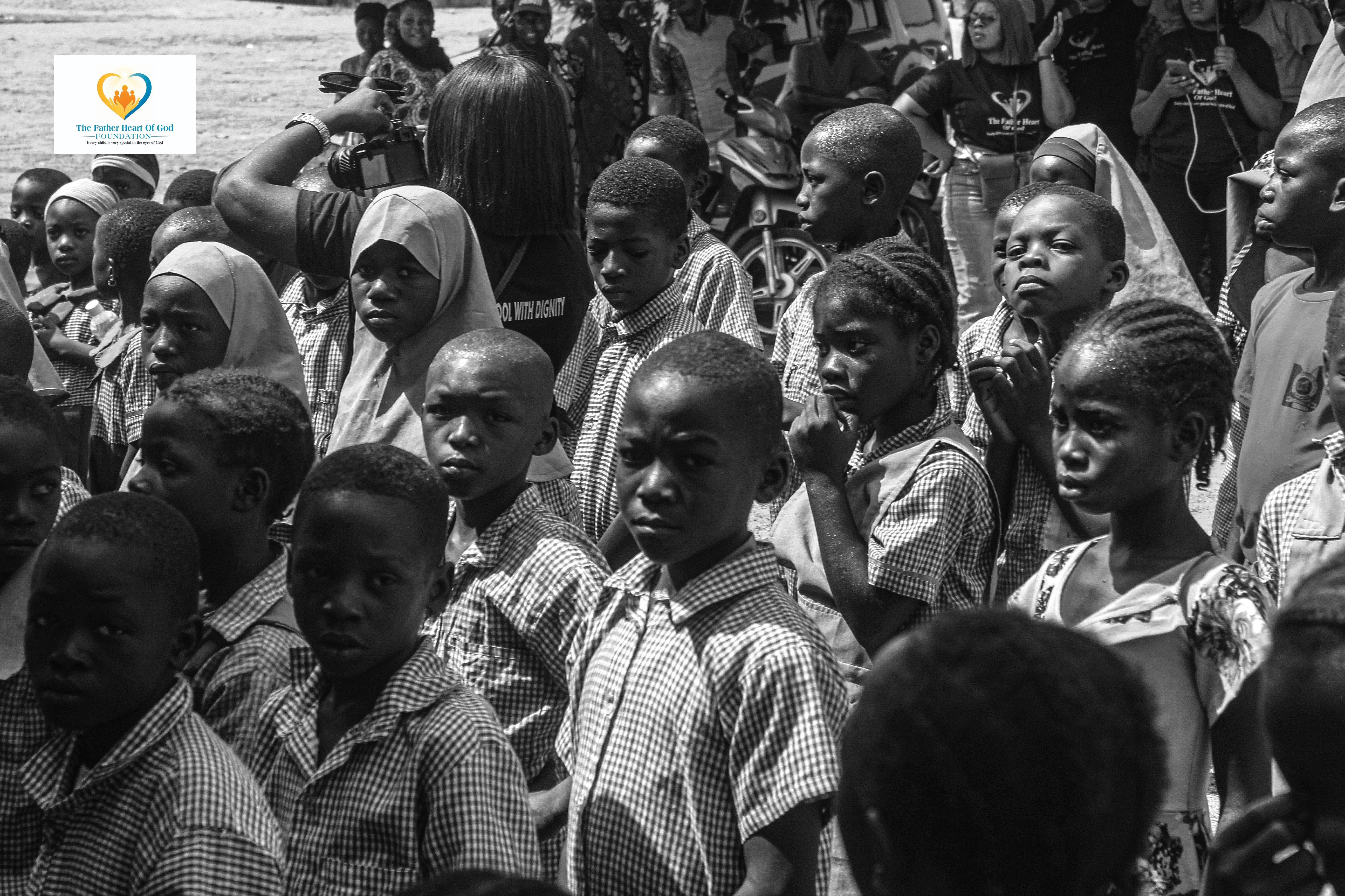 Community celebration with children and volunteers under tree